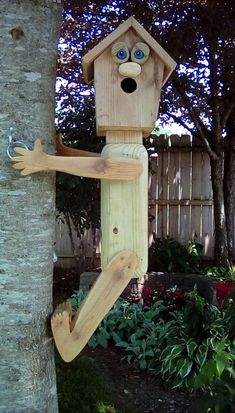 a wooden birdhouse hanging from the side of a tree