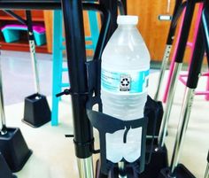 a bottle of water sitting on top of a black stand next to some stools