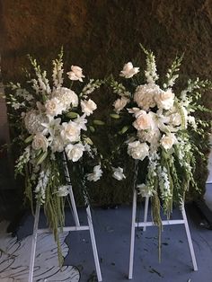 three vases with white flowers and greenery