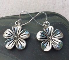 These earrings are beautifully adorned with a dimensional flower design.  Made from allergy free plated silver.The charm measures 3/4". They are lightweight so they are very comfortable.I have the matching necklace in my shop if you would like the whole set.https://www.etsy.com/listing/163102810/silver-flower-pendant-silver-flowerPlease visit the rest of my shop, as I have many lovely adornments to look at and covet. Simple Silver Earrings Flower, Sterling Silver Jewelry With 3d Flower Design, Nickel Free Flower Earrings For Anniversary, Nickel-free Flower Earrings For Anniversary, Silver Flower Earrings For Pierced Ears, Silver Dangle Earrings With 3d Flowers, Silver Drop Earrings With 3d Flowers, Silver 3d Flowers Drop Earrings, Silver 3d Flower Earrings