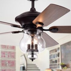 a ceiling fan with two light bulbs and a glass shade hanging from it's blades