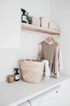 a laundry room with white walls and open shelving