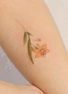 a small flower tattoo on the arm