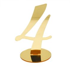 the number four is made out of gold metal and sits on top of a plate