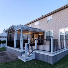 a house with a deck and railings in front of it