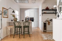 a kitchen with white walls and wooden floors