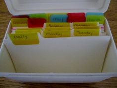 a white box filled with lots of different colored sticky notes on top of a wooden table