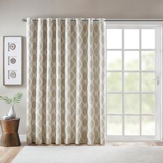 a living room with a white rug and curtains on the window sill next to a potted plant