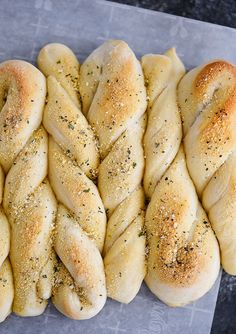 several braided breads sitting on top of a piece of paper with seasoning sprinkled on them