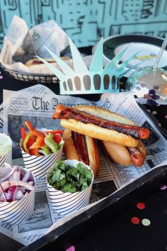 hot dogs and salads in paper cups on a tray