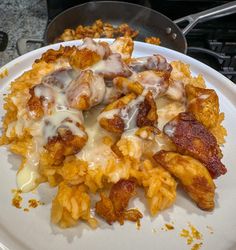 a white plate topped with pasta and meat covered in sauce on top of a stove