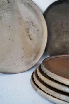 a stack of dirty plates sitting on top of a white tablecloth covered floor next to each other