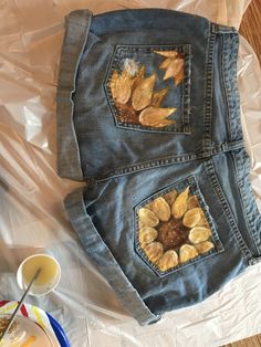 two jeans with leaves painted on them