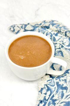 a cup of hot chocolate on a blue and white cloth