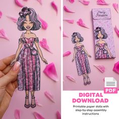 the paper doll is being held up to show it's cut out and ready to be