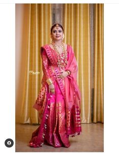 a woman in a pink sari posing for a photo with her hands on her hips