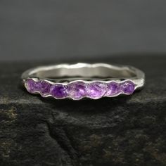 "Raw Amethyst Band Ring // Unique Rustic Organic Alternative Raw Rough Uncut Natural Purple Gemstone Amethyst Crystal Wedding Band Ring This listing is for one raw natural Amethyst band ring. Pictured ring is in sterling silver. DETAILS:  Stone: natural raw Amethyst Metal:  - 925 silver  - 14k yellow, rose and white gold (stones appear darker in gold) - 18k yellow gold (stones appear darker in gold) Band Width: approx. 2x1mm, hammered Stone part size: approx.2mm high and around 2.7-3mm wide Note Amethyst Gemstone Stackable Rings For Wedding, Wedding Amethyst Gemstone Stackable Rings, Purple Gemstone Stackable Rings For Wedding, Purple Amethyst Stackable Wedding Rings, Purple Faceted Jewelry For Wedding, Faceted Amethyst Wedding Ring, Adjustable Amethyst Crystal Wedding Ring, Amethyst Stackable Wedding Rings, Purple Amethyst Stackable Ring For Wedding