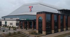 an empty parking lot in front of a building with a giant t sign on it