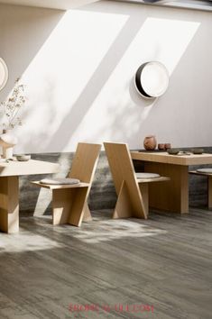 an empty room with several wooden tables and stools in it, all facing the same direction