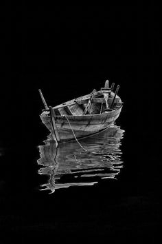 a black and white photo of a small boat in the water with no people on it