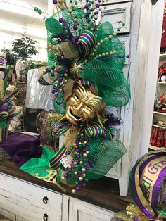 a green and gold wreath on top of a white cabinet in a room filled with other items