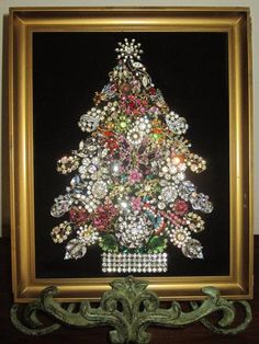 a christmas tree made out of jewels in a gold frame