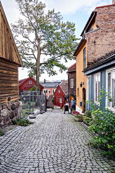 two people are walking down the cobblestone street