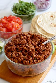 lentil walnut tacos in a glass bowl with tortilla chips and lime wedges