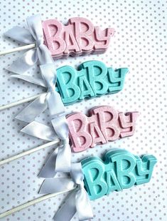 baby shower cake toppers with bows on white polka dot paper and blue and pink icing