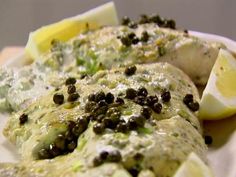 a close up of food on a plate with broccoli and black olives