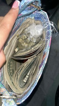 a person holding money in their purse with plastic wrap around it's edges and inside