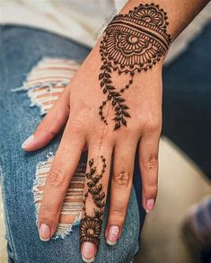 a woman's hand with henna tattoos on it