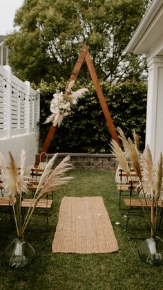 an outdoor ceremony set up with chairs and flowers in vases on the grass area