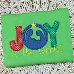 a green shirt with the word joy to the world on it and a star in the middle