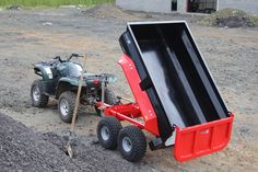 an atv pulling a trailer behind it in the dirt