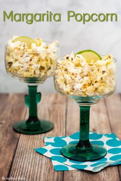 two glasses filled with popcorn sitting on top of a wooden table