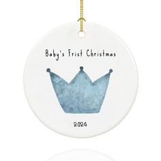 a baby's first christmas ornament with a blue crown on the front