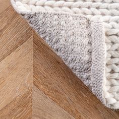 a close up view of a wooden floor with a rug on it and the top part of the wood