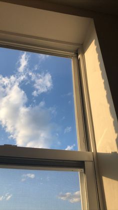 the sky is blue and white with clouds in it, as seen through a window