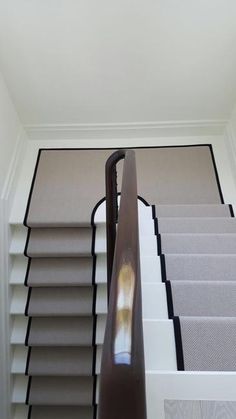 the stairs are lined with gray carpet and white walls