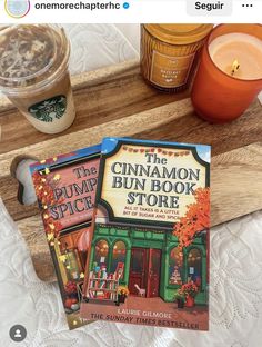 the cinnamon bun book store is on display next to two candles and a cup of coffee