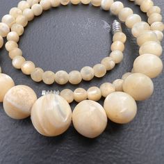 Vintage ~ round Mother or pearls (MOP ) ~ graduating size bead /beaded necklace ~ necklace has barrel clasp at end  Dates mid to late 20th century . Material : MOP metal Measurements: necklace is 17 1/4  inches in length x 1/2 inches max width (min size of 1/4 inches )  . Weighs 33 grams on my weighing scale . Condition :  good vintage condition with very less surface wear to beads ~ No major cracks or chips to the beads . Please Note ~ As vintage items are previously loved /used please do expect some minor wear like surface wear /dents /dings and metal discoloration . All items are carefully inspected and major flaws will be listed separately ~ Plenty of photograph are added so please study the photos carefully as it is also part of description or if you need more pictures just message us Pearl Beaded Necklaces With Gemstone Beads, Round Pearl Beaded Necklaces With Gemstone Beads, Classic Handmade Pearl Necklace With Round Beads, Round Pearl Beaded Necklaces With Polished Beads, Large Beads Pearl Necklace, Pearl Necklace With Large Round Beads, Single Strand Pearl Necklace With Round Beads, Pearl White Necklace With Large Round Beads, Cream Single Strand Pearl Necklace