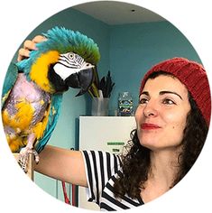 a woman holding a parrot in her hand