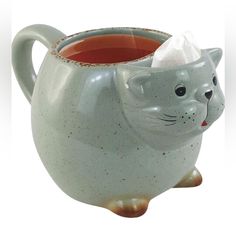 a ceramic mug with a cat design on the side and a tissue dispenser in the middle