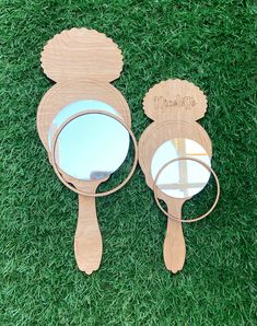 two wooden mirrors sitting on top of green grass