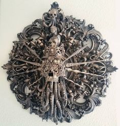 an intricately designed metal clock is hanging on the wall