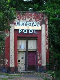 an old red building with the words crystal pool painted on it's front door