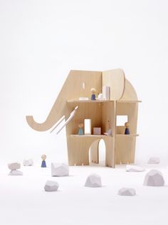 an elephant is standing in front of a shelf with figurines on it's sides