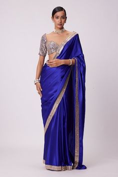 Persian blue saree crafted in satin with prism sheesha embroidery on the border. Paired with a half sleeves sweetheart neck blouse with mirror-vine embroidery. - Aza Fashions Satin Pre-draped Saree With Pallu For Wedding, Wedding Satin Pre-draped Saree With Pallu, Blue Tissue Silk Pre-draped Saree For Reception, Traditional Satin Saree For Reception, Blue Art Silk Saree With Mirror Work, Blue Tissue Silk Blouse Piece For Party, Elegant Blue Chanderi Pre-draped Saree, Elegant Semi-stitched Royal Blue Saree, Fitted Satin Saree For Designer Wear