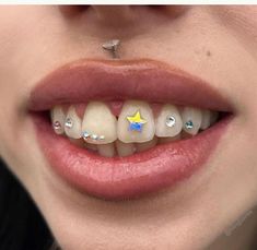 a close up of a person's mouth with fake teeth and piercings on it